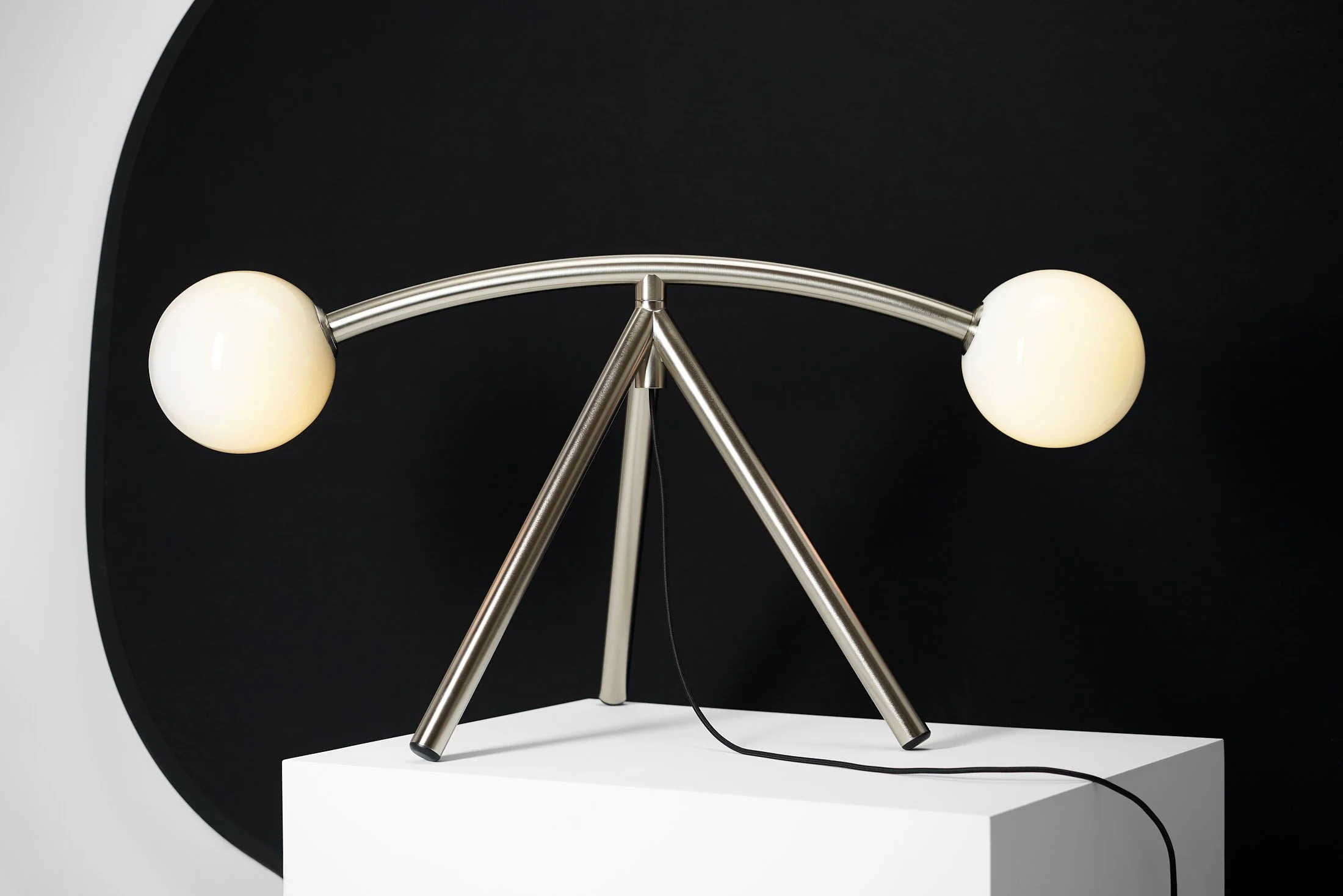 Lampe Rune allumée, finition nickel, sur fond noir